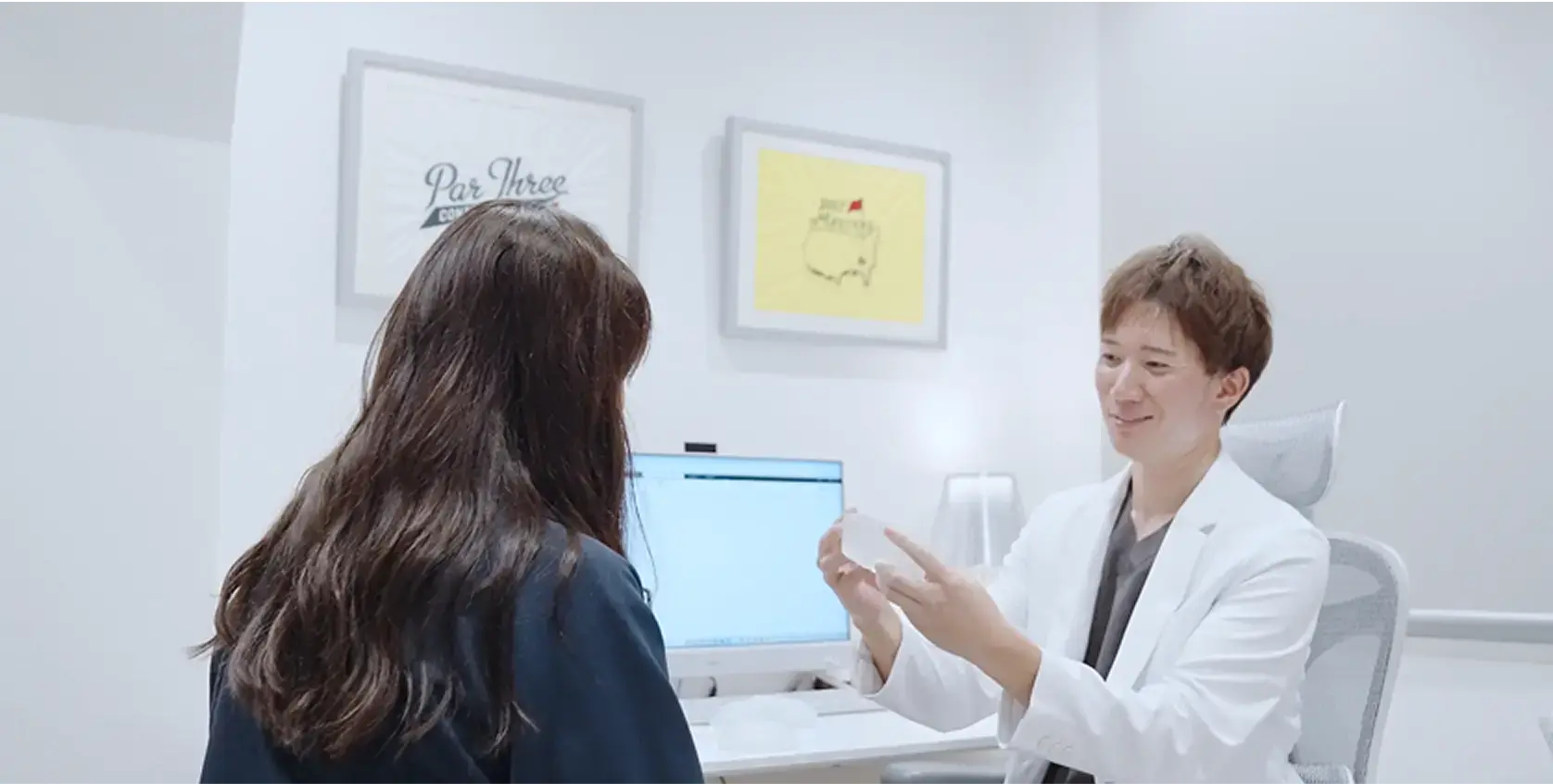 白衣を着た医師が、診察室で患者に対して丁寧に説明をしている